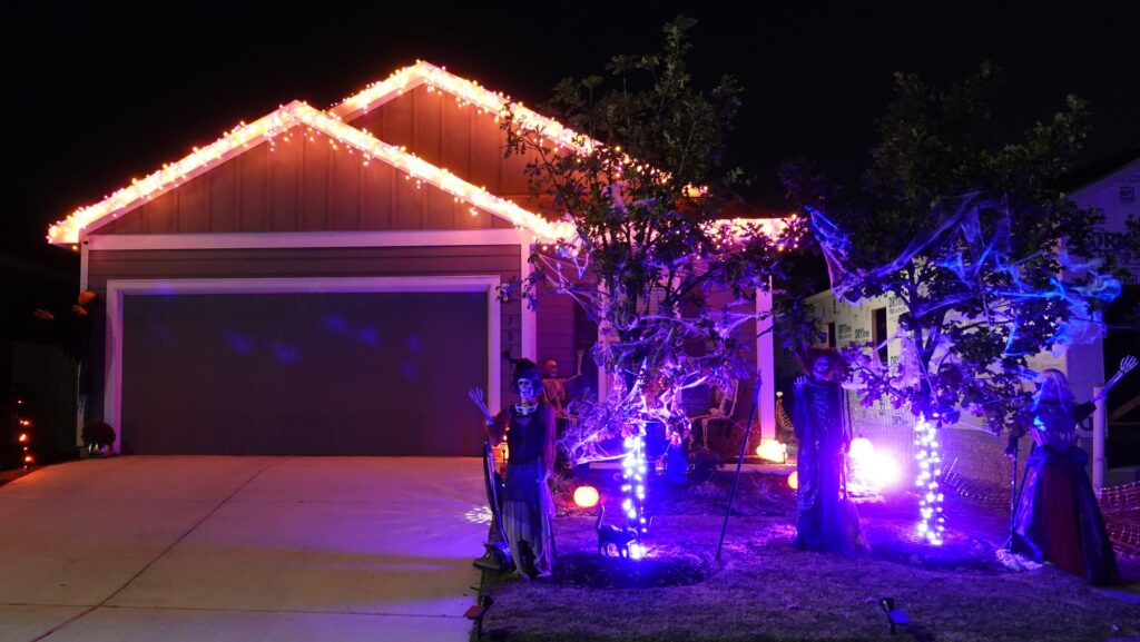 Ben's house decorated with lights and skeletons for Halloween.