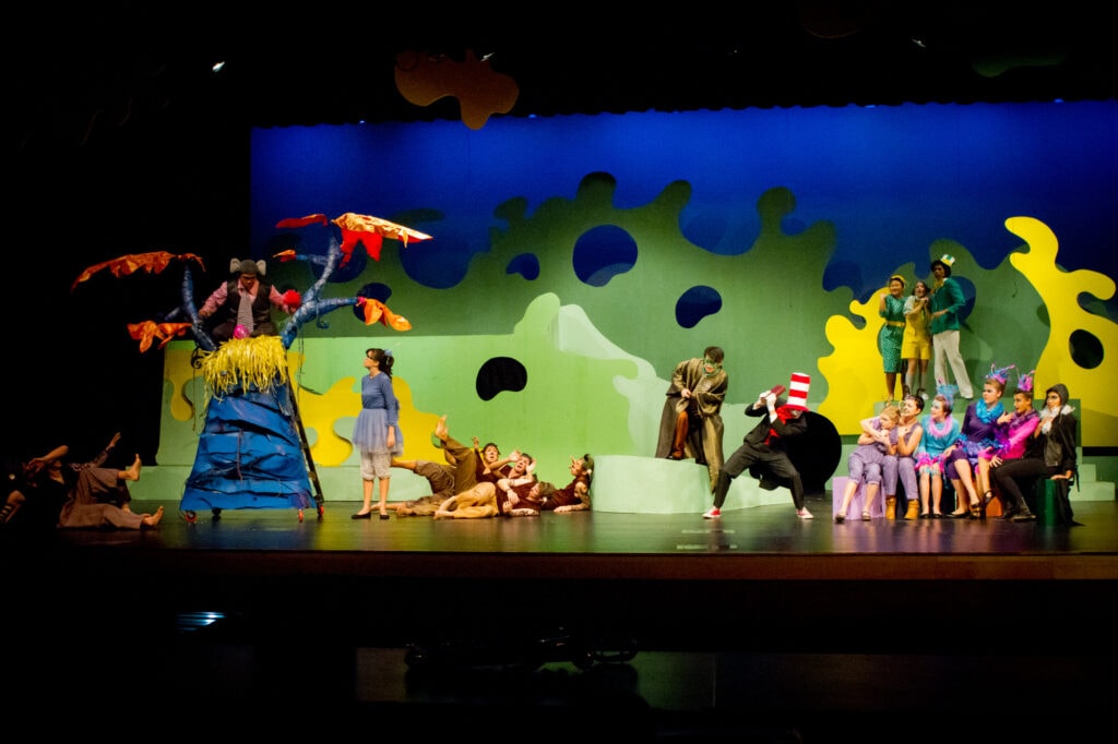 Actors and props for Seussical the Musical arrayed mid-performance on a stage.